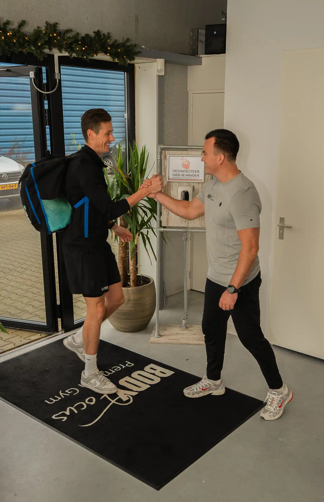 Personal trainer verwelkomt member bij binnenkomst van Body Focus Premium Gym