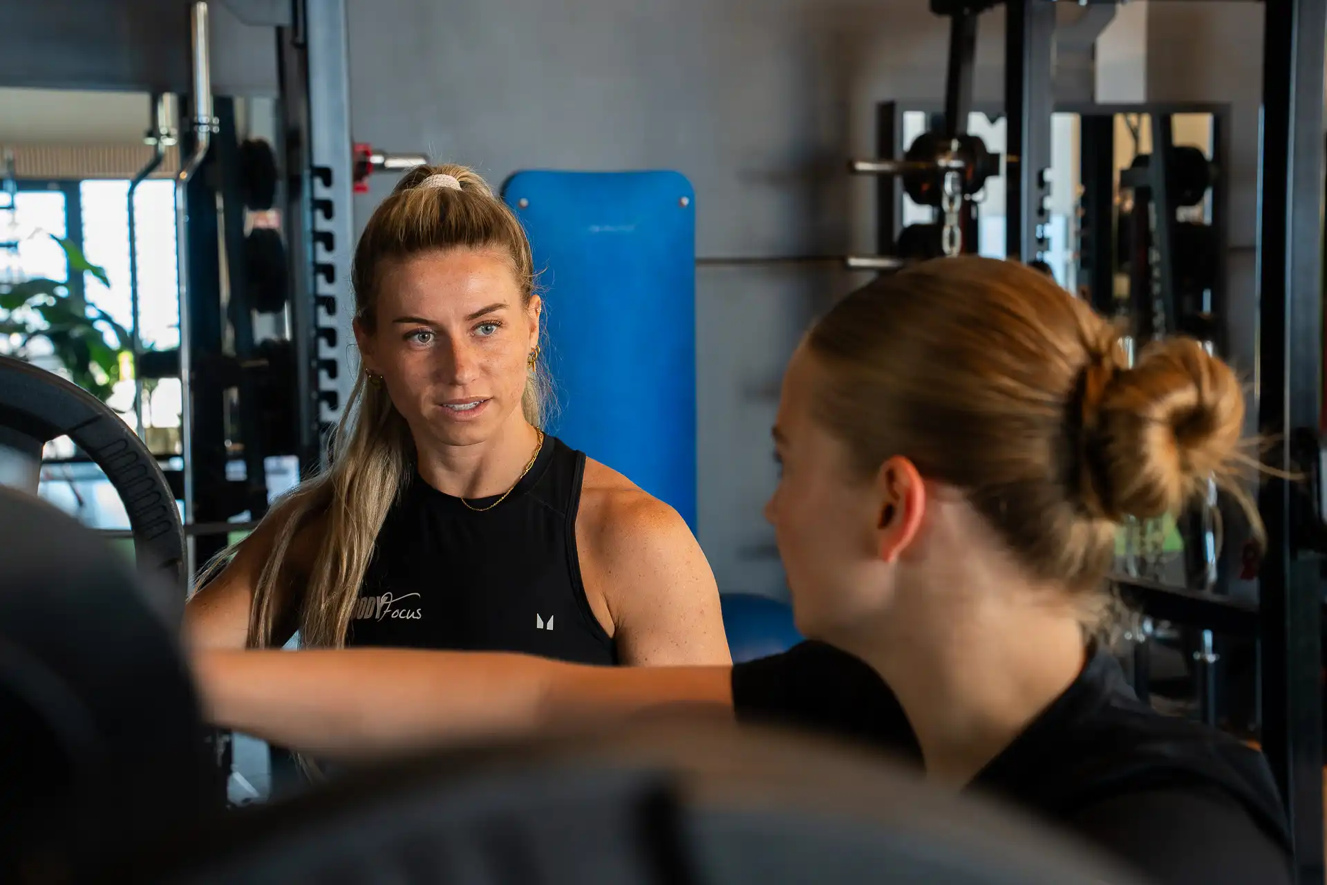 Vrouwelijke personal trainer in gesprek met member tijdens 1-op-1 training bij Body Focus