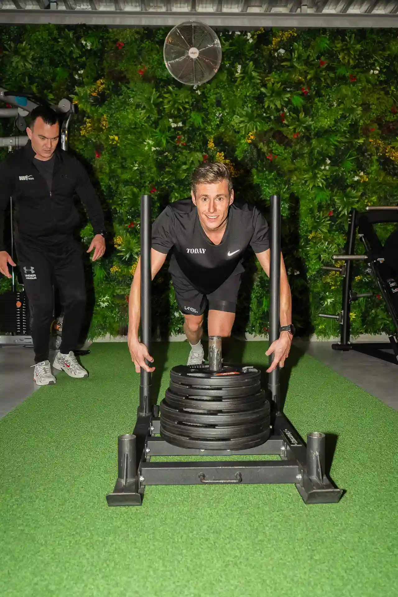 Sled push over de kunstgrasstrook tijdens hybride training bij Body Focus