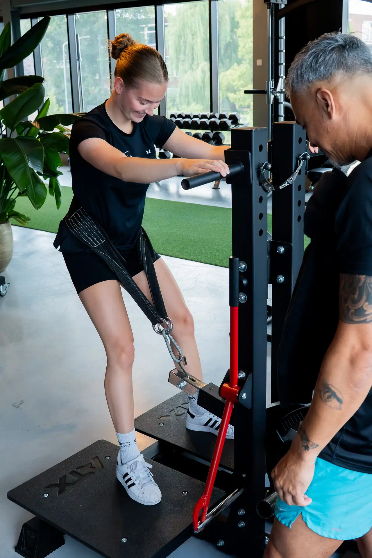 Sportmaatje traint kickback op belt squat rack