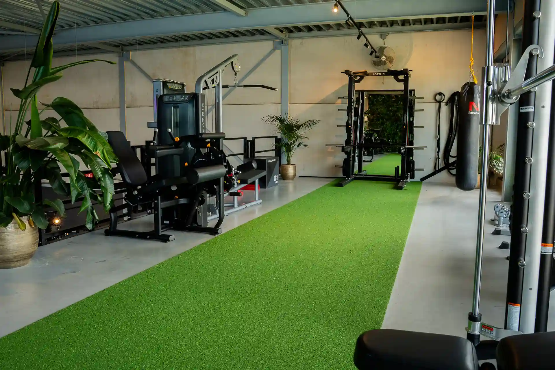 Member draagt twee kettlebells voor een farmers carry in de gym van Body Focus